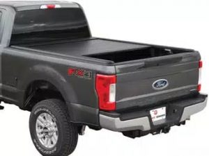 Black Ford truck with the UltraGroove Metal retractable tonneau cover installed, showing the sleek design and built-in Rail Expansion System (RES™) for attaching Thule and Yakima racks